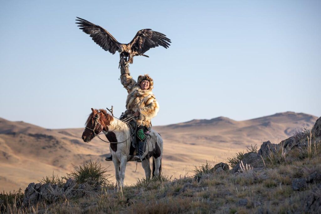 hombre a caballo con aguila que se apoya a su brazo levantado en mongolia, destino a donde viajar en octubre