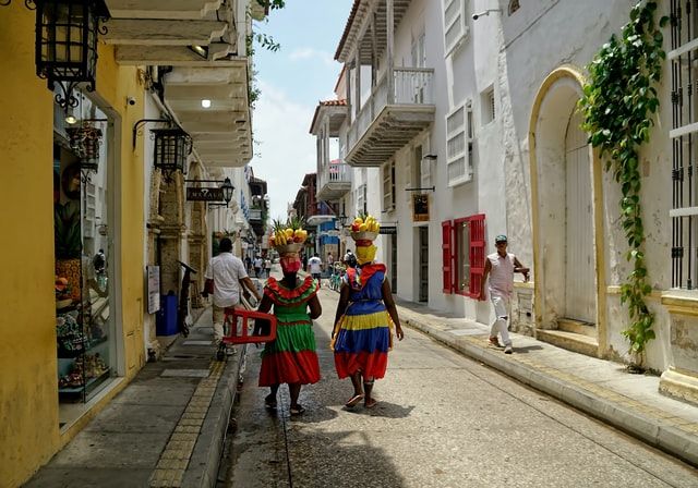 dos mujeres con traés colombianos caminando por las calles de cartagena en colombia - weroad