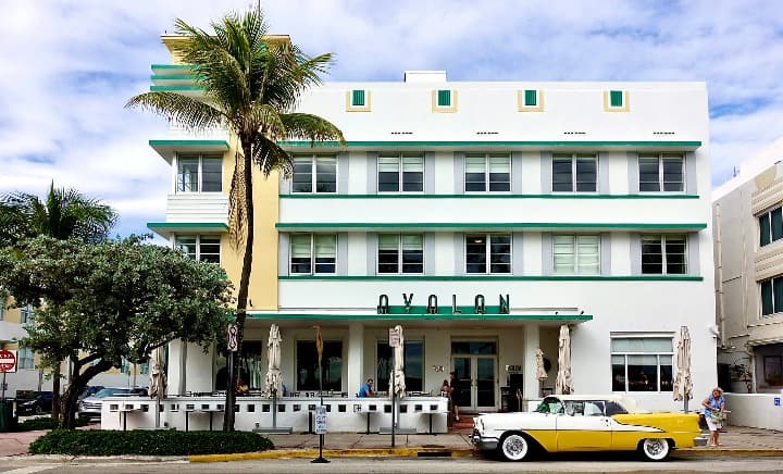 avalon hotel en miami, delante del edificio un coche de época, una palmera  y otro árbol - weroad