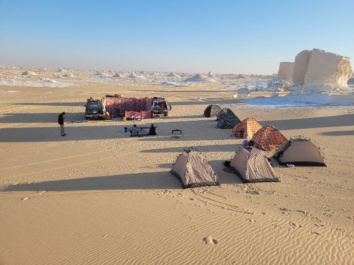tiendas en medio del desierto blanco de egipto, detrás formaciones rocosas blancas - weroad