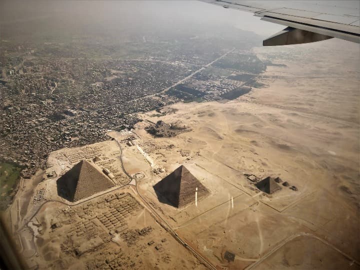 piramides de giza vistas desde un avión, se aprecia la ciudad al margen de una zona desértica - weroad