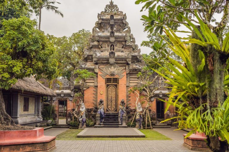 entrada del palacio de puri saren en ubud, arboles y palmeras alrededor - weroad