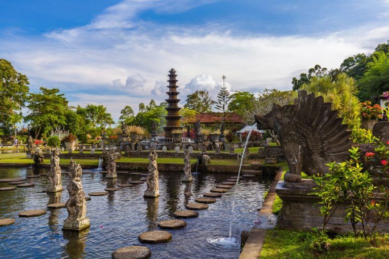 jardines del palacio de tirta gangga en bali con estatuas en las fuentes y vegetación alrededor - weroad