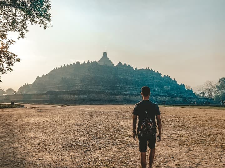 chico de espaldas mirando al templo de borobudur, una de las cosas que ver en indonesia - weroad