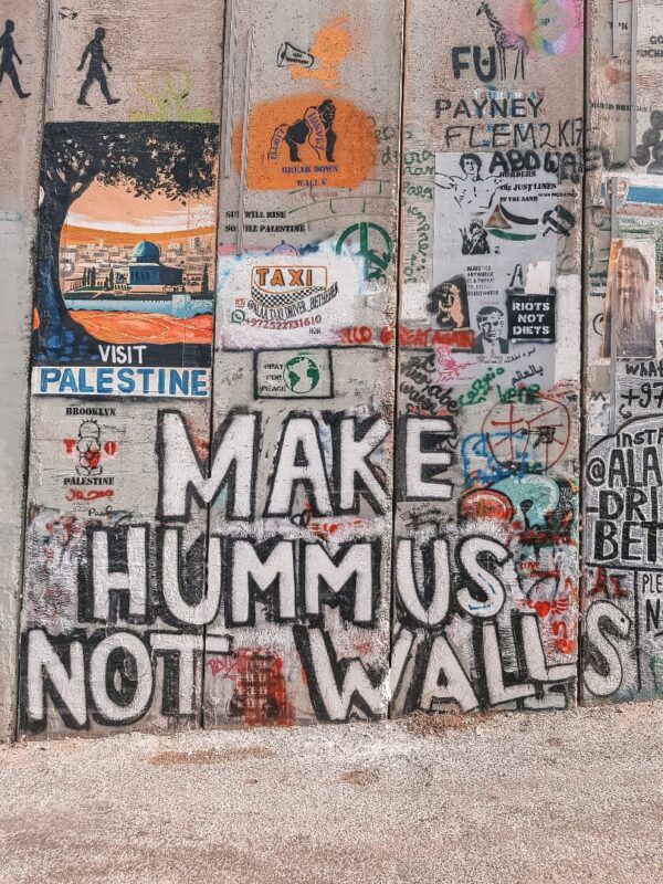 mural de banksy en jerusalén que pone -make hummus not war-, una de las cosas que ver en israel - weroad