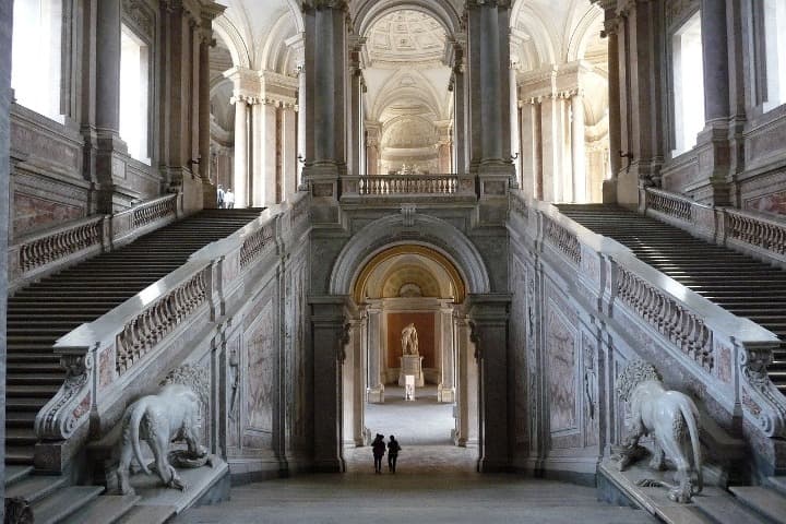 interior del palacio real de caserta, dos escaleras laterales, estatuas de leones, todo en marmol blanco - weroad