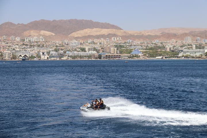 dos chicos en moto de agua con detrás eilat, ciudad que ver en israel - weroad