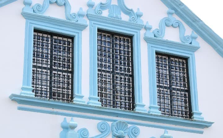 fachada de una casa de terceira, tres ventanas con decoraciones azules - weroad
