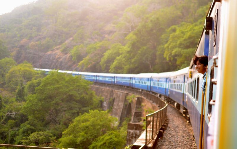 persona asomándose de la ventanilla en un tren en la india, destino para viajes para solteros - weroad
