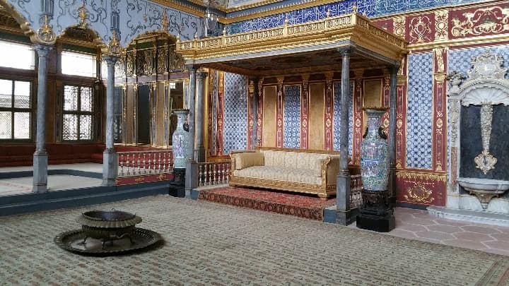 interior del palacio de topkapi en estambul, un sofá bajo un dosel y paredes decoradas con baldosas azuladas - weroad