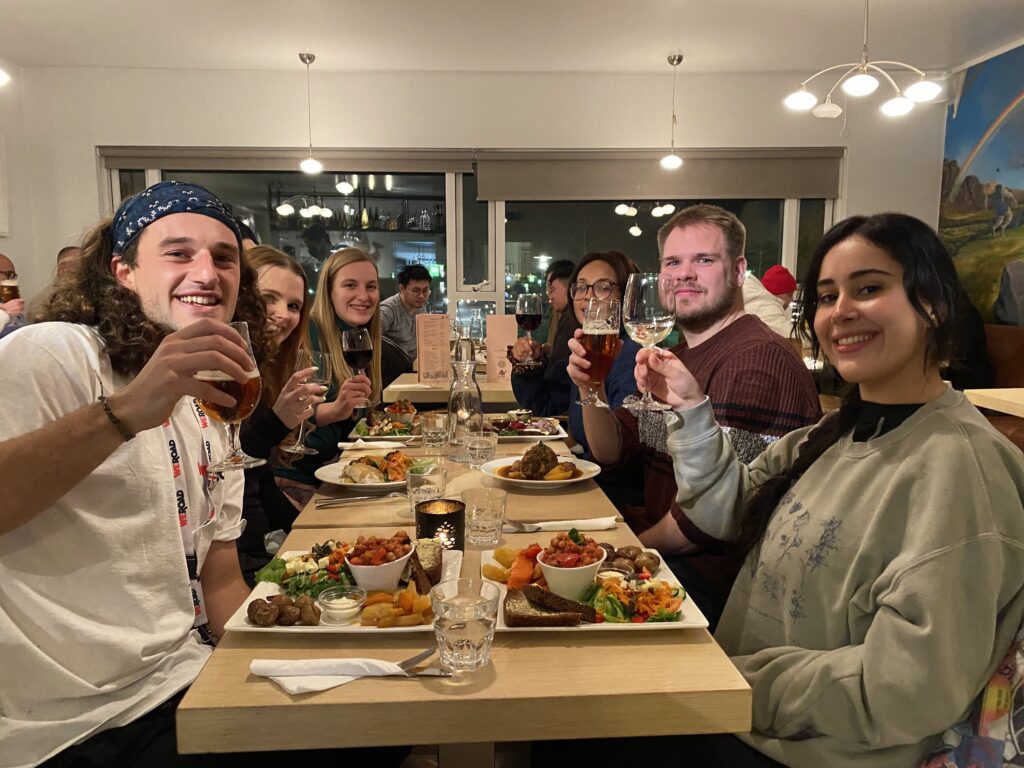 seis viajeros de weroad en una mesa brindando y con delante platos de cosas que comer en islandia