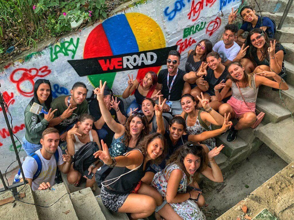 foto de grupo de viajeros de weroad pintando un mural en la comuna 13 en medellin, ciudad que ver en colombia