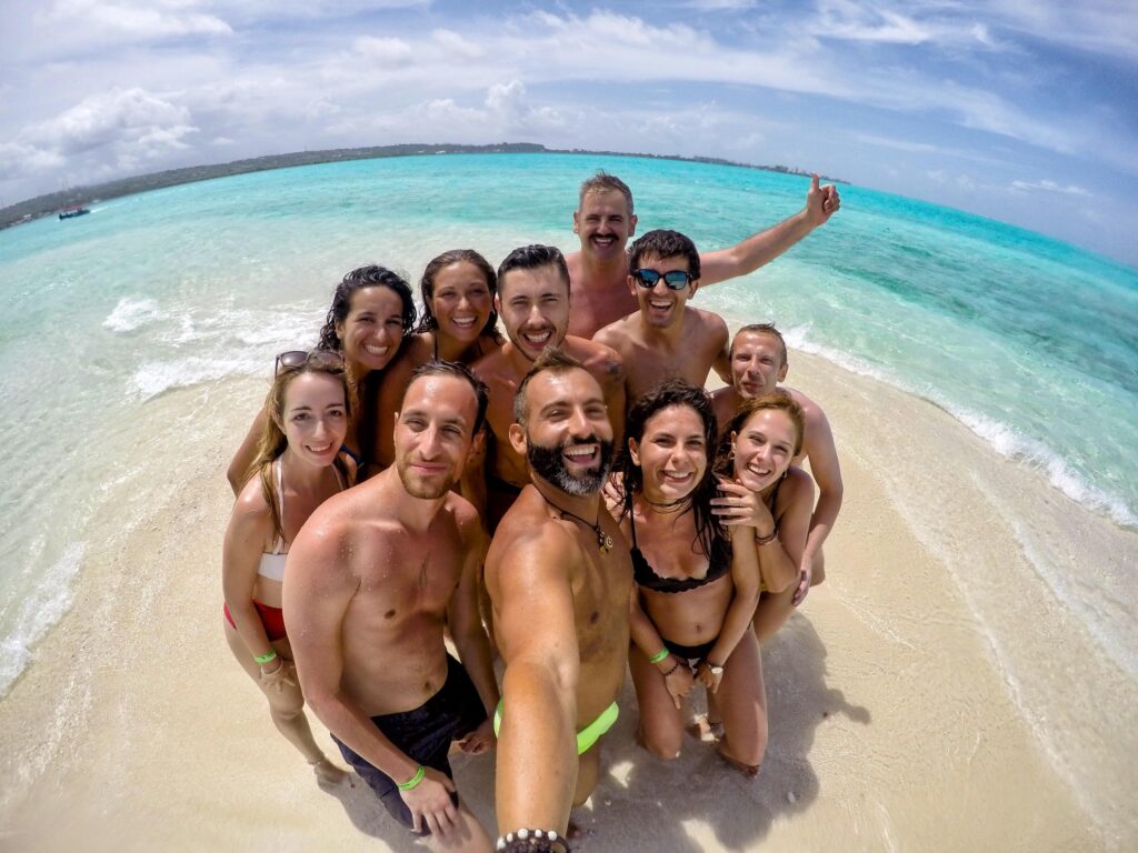 selfie de grupo de viajeros weroad en una playa de colombia, agua cristalina a sus espaldas