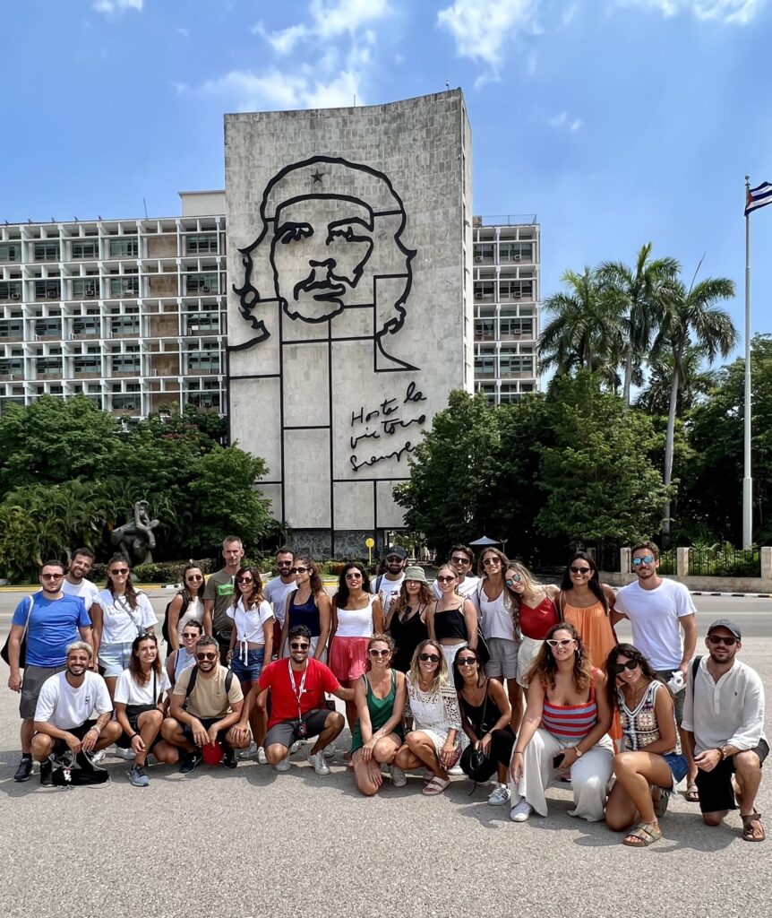 grupo de viajeros de weroad posando delante del che guevara pintado en un edificio en la habana, algo que ver al viajar a cuba