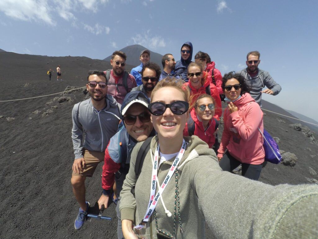 selfie de grupo de viajeros weroad encima del volcán etna, una de las cosas que ver en sicilia