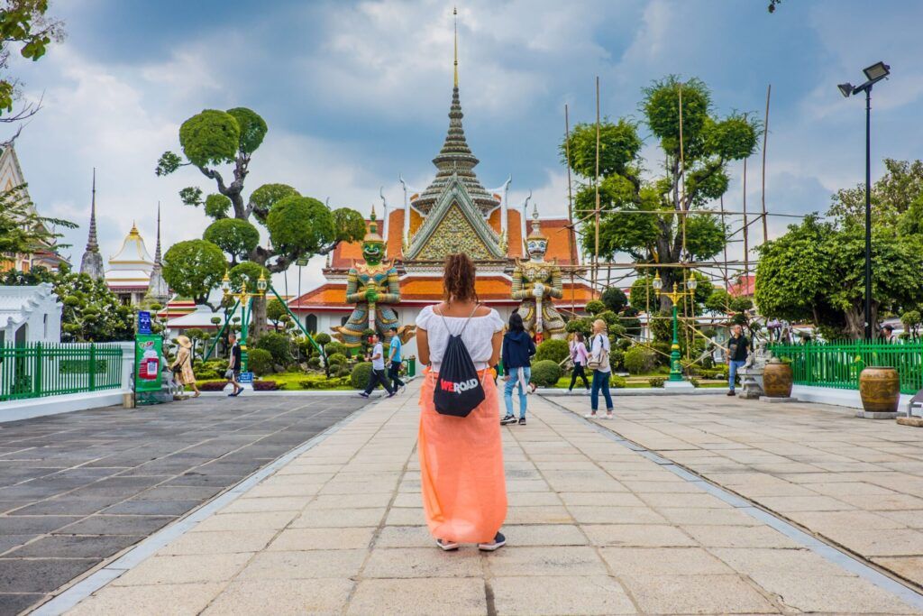 viajera de weroad con su mochila, de espaldas delante de un templo