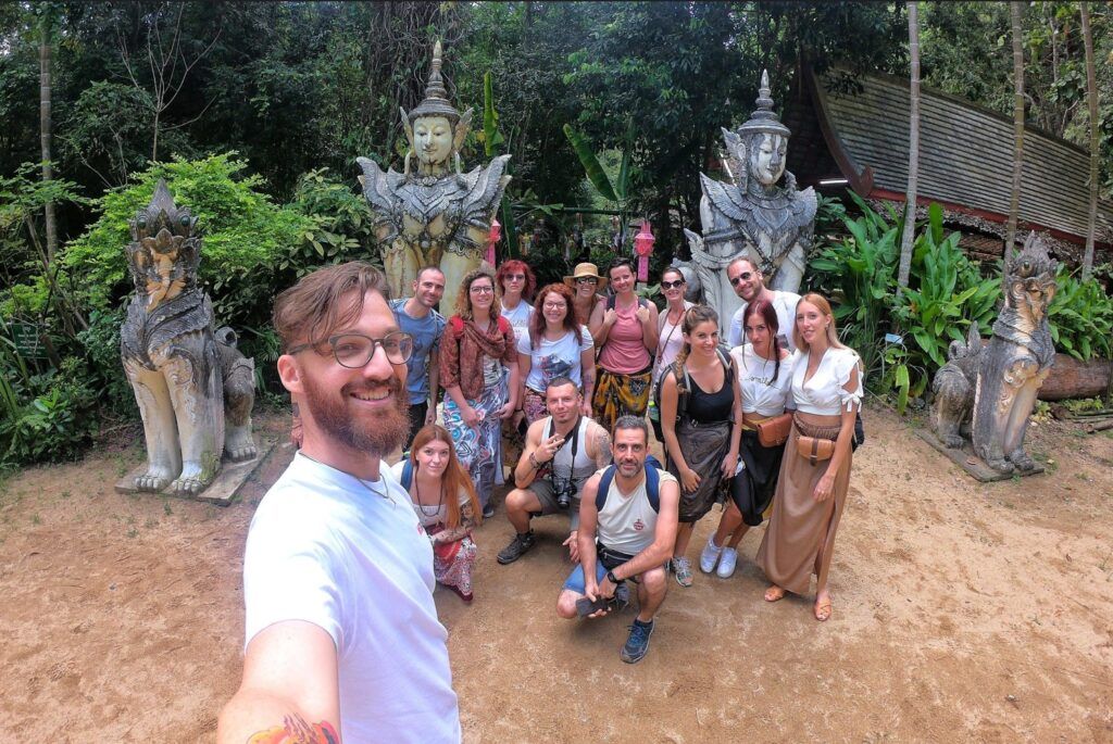 selfie de viajeros de weroad en tailandia, destino ideal para viajes para solteros, detrás unas estatuas - weroad