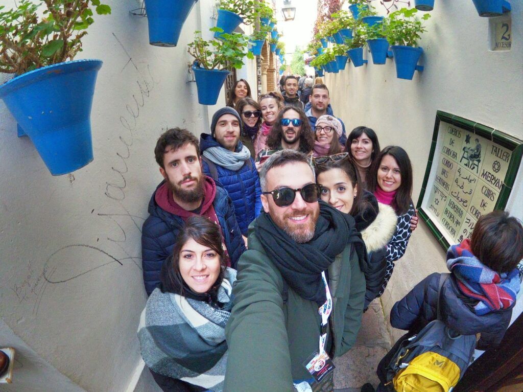 selfie de grupo de viajeros weroad en una calle de cordoba, andalucía, destino ideal para viajar en fin de año