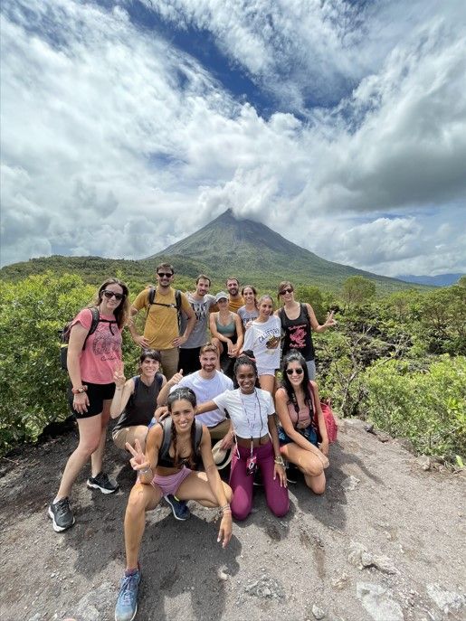foto de grupo de viajeros weroad con detrás el volcán arenal en costa rica