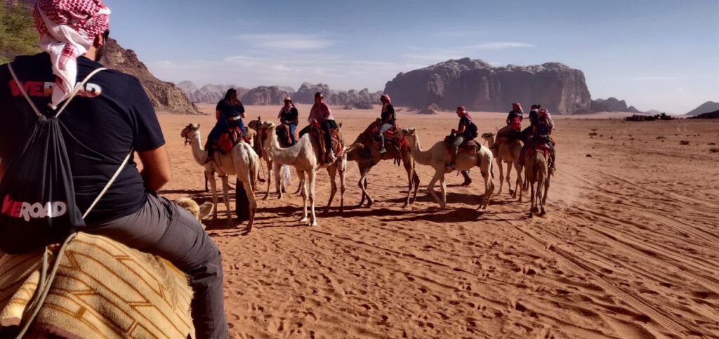 viajeros de weroad montados en camello en el desierto del wadi rum, destino al que viajar en fin de año