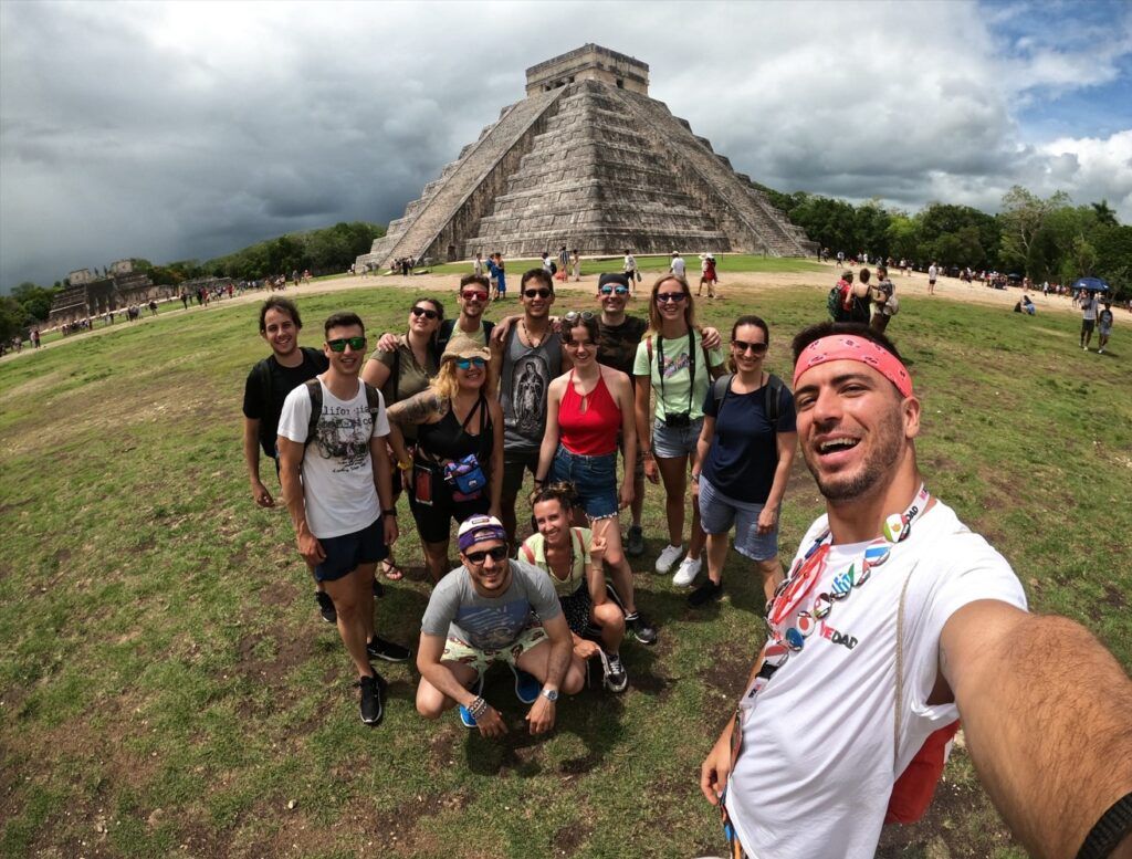 selfie de grupo de viajeros weroad delante de la piramide de chichen izta en méxico, destino al que viajar en fin de año