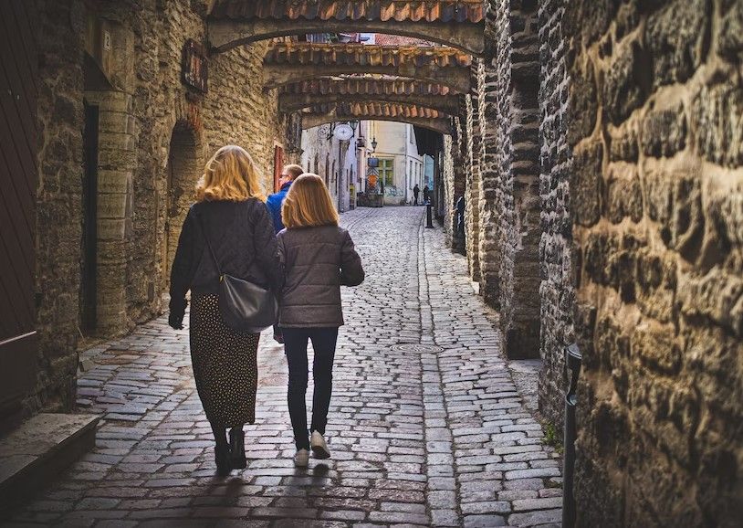 mujer y niña caminando en una calle antigua de tallin - weroad