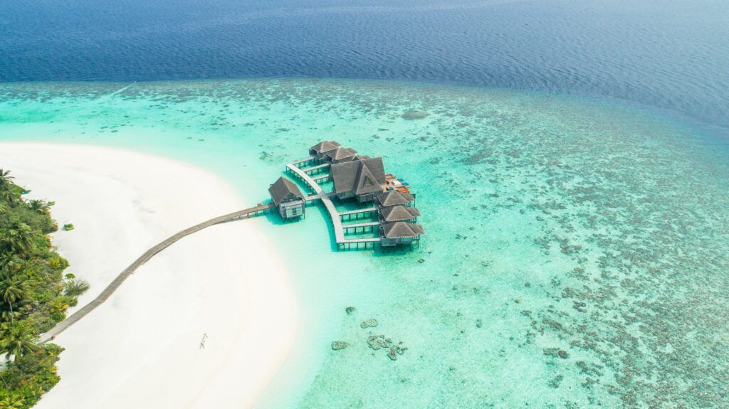 agua turquesa y conjunto de casitas-hotel en el mar de maldivas, lugar donde viajar en enero con calor - weroad