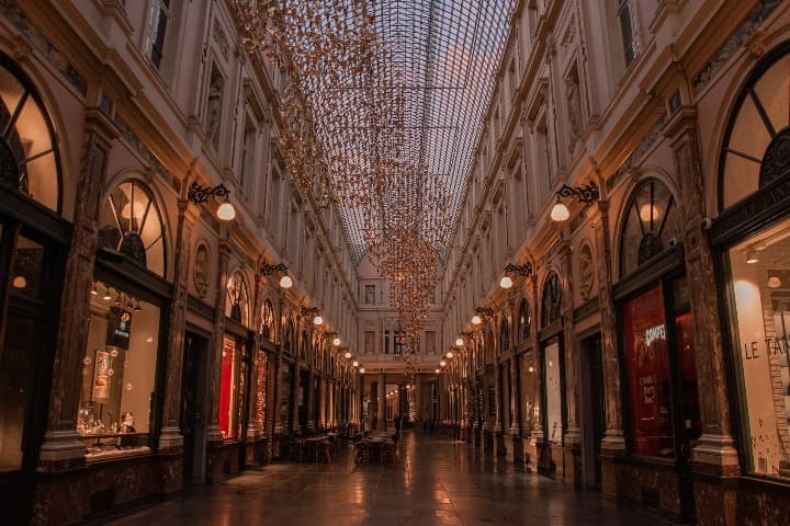 galerias saint hubert, algoque ver en bruselas, escaparates iluminados y luces colgando del techo - weroad