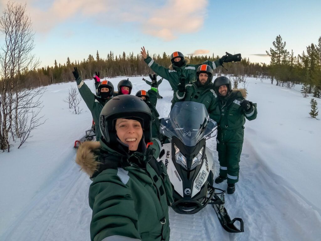 selfie de grupo de viajeros weroad con una moto de nieve en la laponia sueca