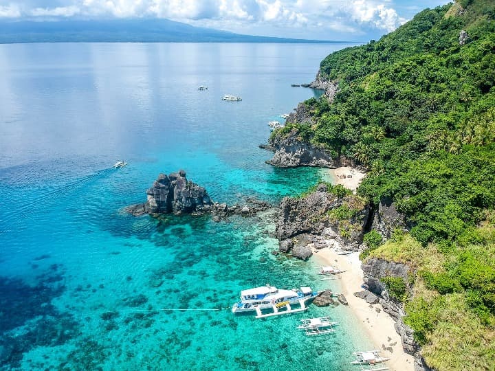 costa de la isla de apo en filipinas, mar cristalino, un yate y naturaleza frondosa - weroad