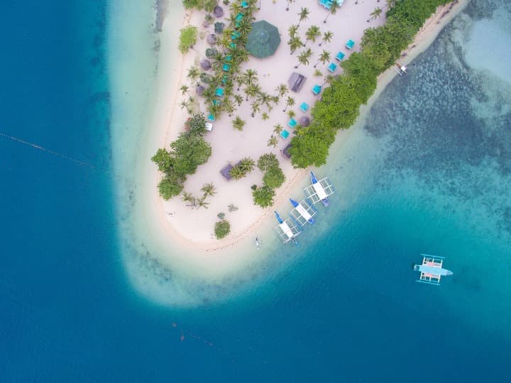 vista aerea de la isla en la provincia de palawan, barcos, arboles y casas - weroad