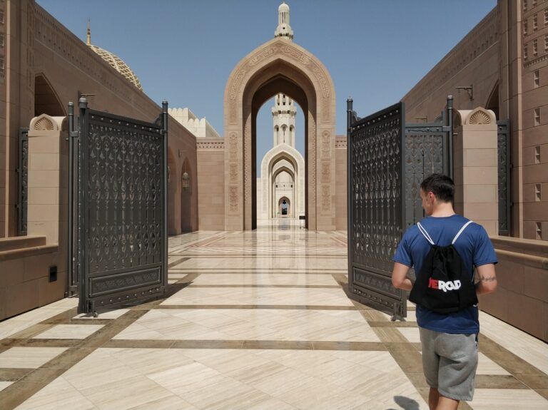 viajero con mochila de weroad cambiando en la zona exterior de una mezquita, algo que ver en oman