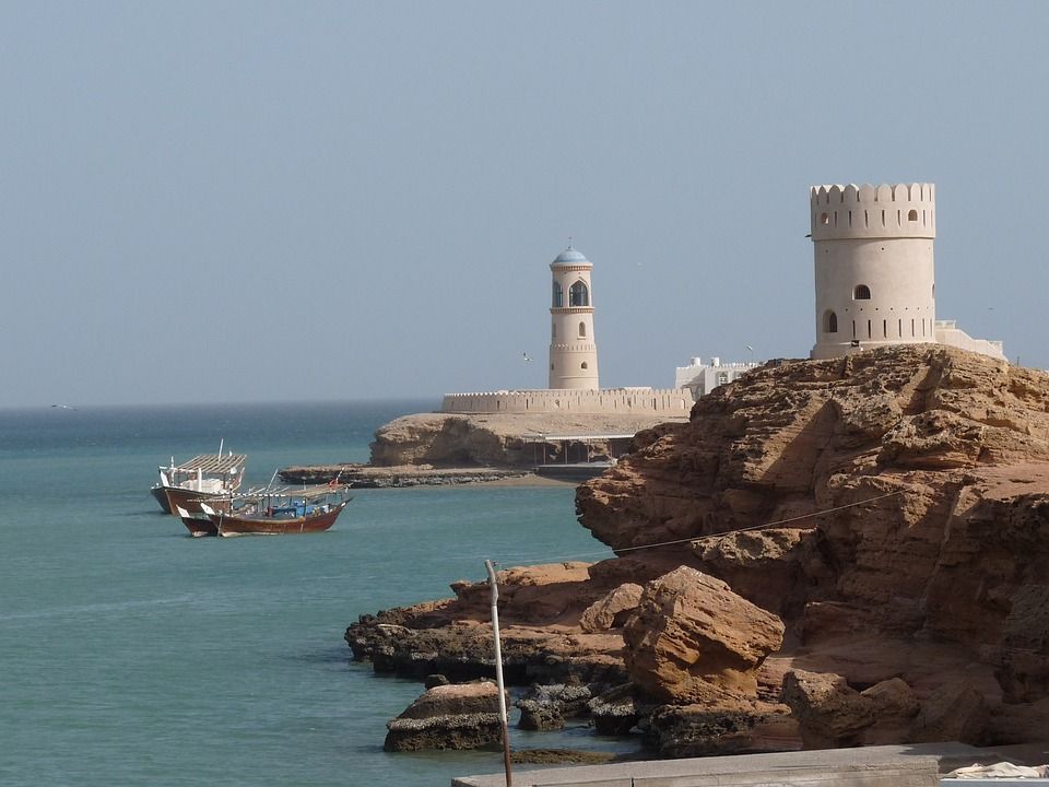 torre y faro cerca del mar, un par de barcos en sur, en oman - weroad
