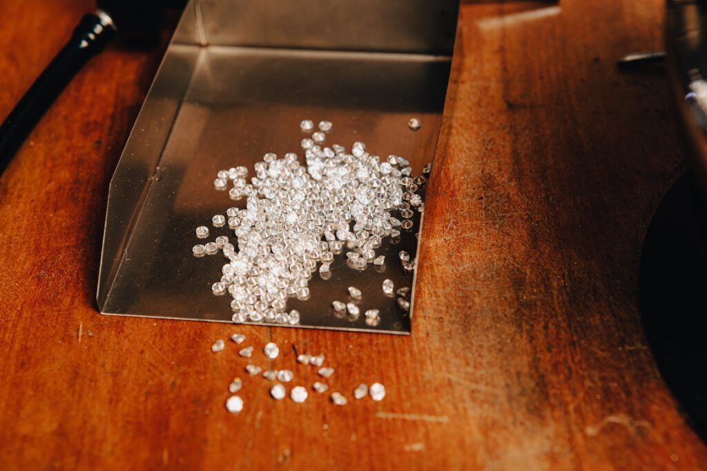 diamantes en una pala de metal encima de una mesa de madera en el museo del diamante - weroad