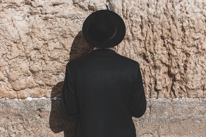 hombre de espaldas rezando ante el muro de las lamentaciones - weroad