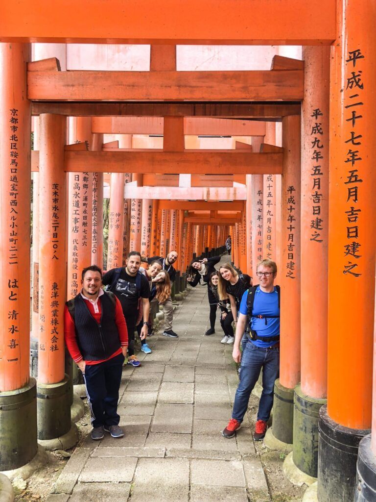 viajeros weroad entre las columnas rojas y negras del santuario fushimi, japon es el destino ideal para viajar solo