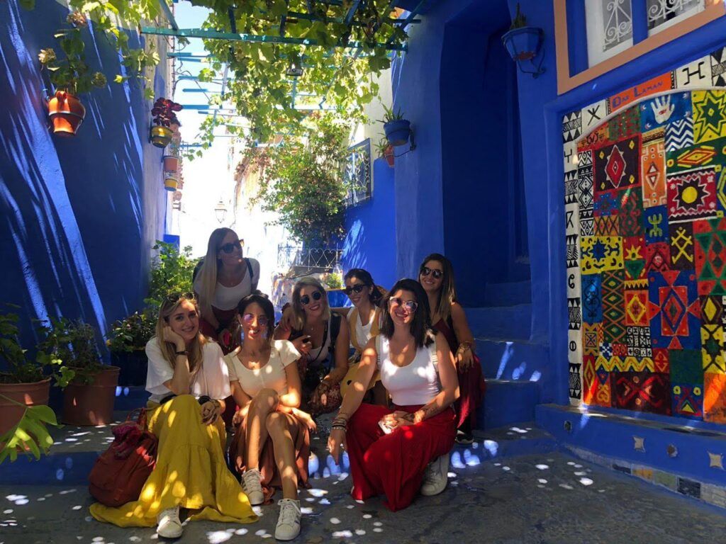 grupo de viajeros weroad en el jardin de una casa con paredes de color azul, algo que ver en marrakech