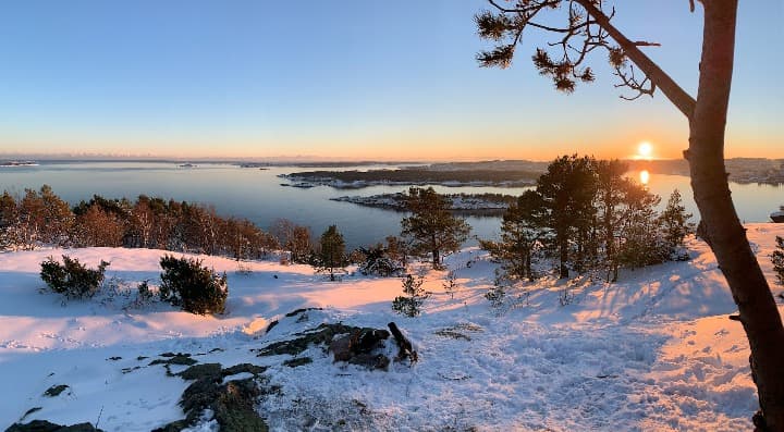 paisaje de nieve y fiordos al atardecer en kristiansand, noruega - weroad