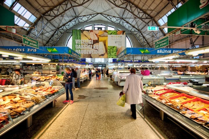 paradas de comida en el mercado central, algo que ver en riga, personas caminando en su interior - weroad