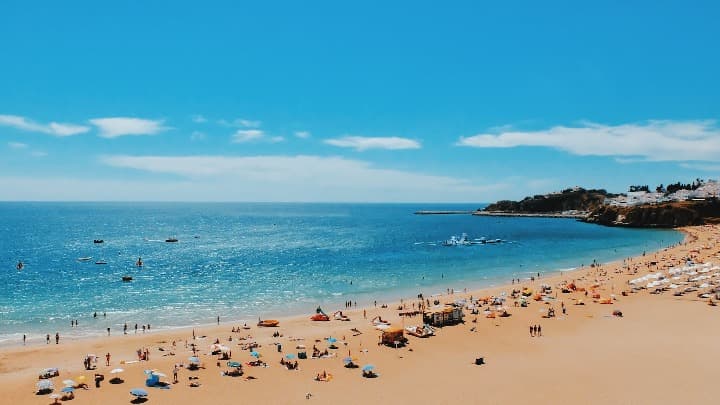 albufeira, una de las playas de portugal que visitar, personas y cielo azul - weroad