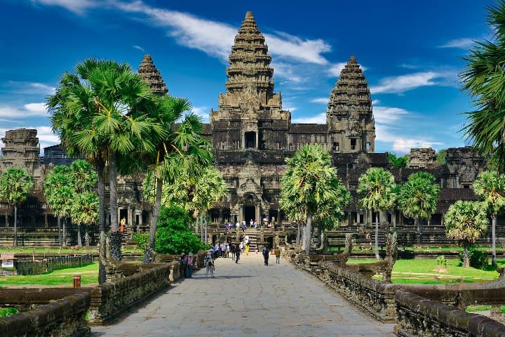 templo de angkor wat, aroboles delante y cielo azul, en camboya - weroad
