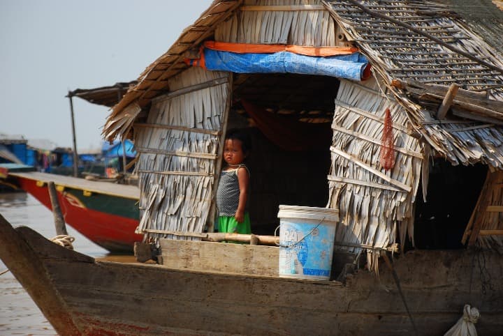 embarcación típica con niña dentro en el lago de Tonlé Sap en camboya - weroad