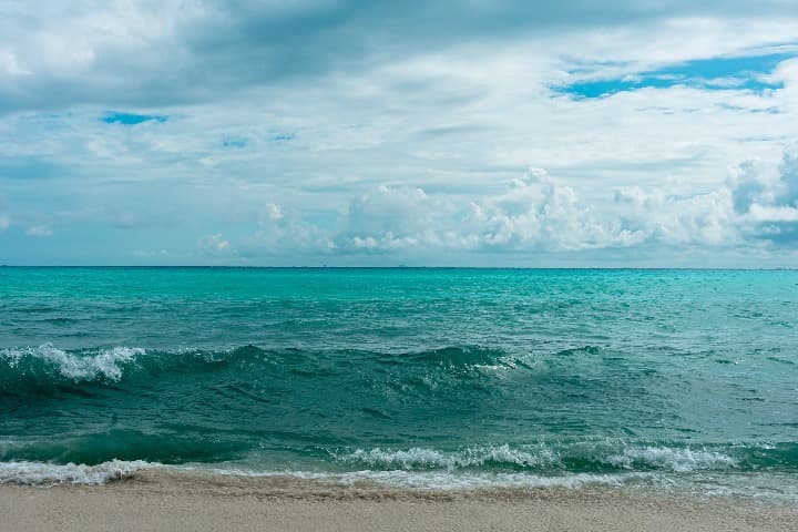 agua azul y cielo con nubes en playa del carmen, mexico - weroad