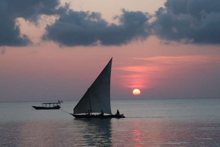 típico barco de zanzibar en la playa de ungwi con puesta del sol detrás - weroad