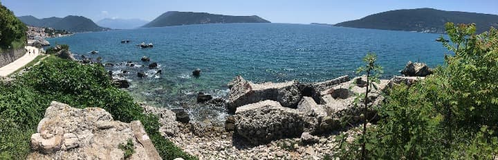 playa de Herceg Novi en montenegro, rocas y montñas al fondo - weroad