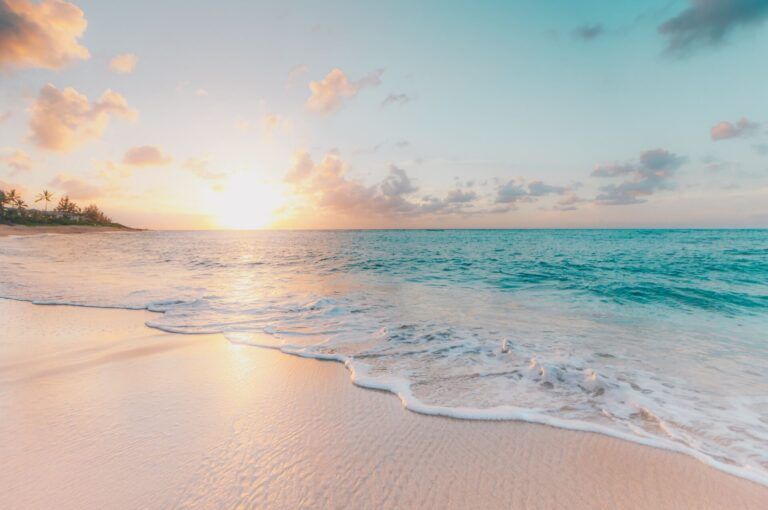 playa con arena rosada y agua azul, sol al fondo en beritnica, croacia - weroad