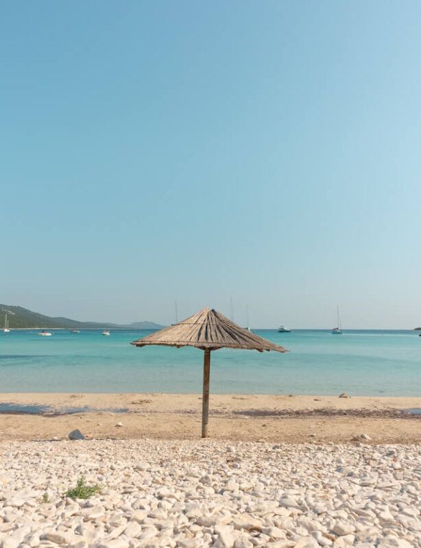 sombrilla de paja en medio de la playa de sakarun en croacia - weroad