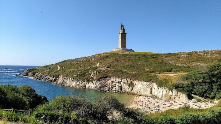 torre de hercules, faro en a coruña en medio a un espigón con mar alrededor - weroad