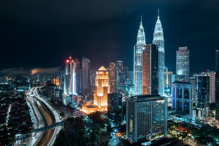 rascacielos y edificios iluminados de noche en kuala lumpur, malasia - weroad