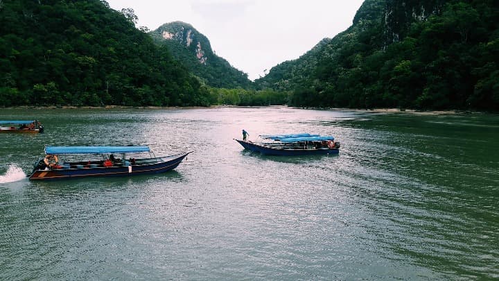 barcos y montaña verde al fondo en Langkawi, malasia